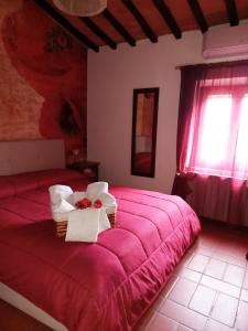 a bedroom with a red bed with a basket of flowers on it at Poppy's House in Casole dʼElsa