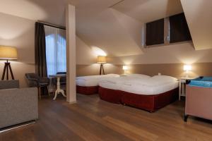 ein Hotelzimmer mit 2 Betten und einem Tisch in der Unterkunft Hotel Emmental in Thun