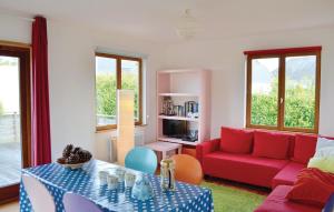 ロクテュディにあるNice Home In Loctudy With 2 Bedroomsのリビングルーム(赤いソファ、テーブル付)
