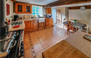 a kitchen with wooden cabinets and a table and a counter at La Grande Chaise in Bonnemain