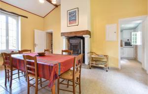 a dining room with a table and chairs and a fireplace at Nice Home In La Chapelle Hermier in La Chapelle-Hermier