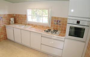 a kitchen with a stove and a sink and a window at Nice Home In La Chapelle Hermier in La Chapelle-Hermier