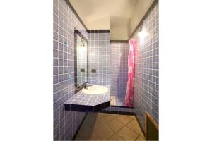 a blue tiled bathroom with a sink and a mirror at Baia Del Faro in Palau