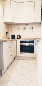 a white kitchen with white cabinets and a stove at Wici 2 Apartments Teofilow Wodny Raj in Teofilów