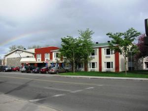 una calle de la ciudad con coches estacionados frente a los edificios en Hotel Le Voyageur en Quebec