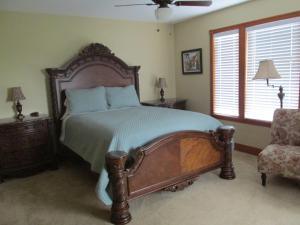 a bedroom with a large bed and a chair at Mansion Inn Lake Stevens in Lake Stevens