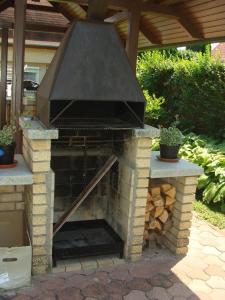 un horno de pizza al aire libre en un patio con plantas en Nyaraló Balatonmáriafürdő, en Balatonmáriafürdő