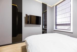 una camera da letto con un letto e una TV a schermo piatto di Fayna Town - Loft Black - Nyvky a Kiev