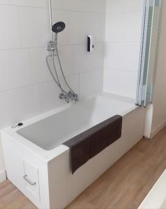 bagno con vasca e lavandino di Au Lutin Pommé - Maison de vacances Bretagne a Mellé
