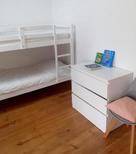 a white bunk bed with a desk and a chair at Au Lutin Pommé - Maison de vacances Bretagne in Mellé