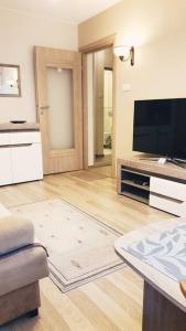 a living room with a flat screen tv and a couch at Studio City centre Lutomierska Manufaktura in Łódź