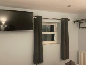 a television on a wall next to a window at Comus Inn in Selby