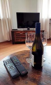 a bottle of wine and a remote control on a table at Gästehaus "Am Marktplatz" in Bad Sobernheim