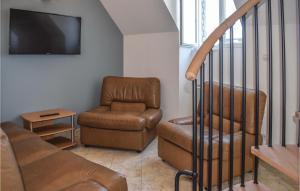 ein Wohnzimmer mit einem Sofa, einem Stuhl und einem TV in der Unterkunft Gorgeous Apartment In Treguier With Kitchen in Tréguier