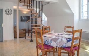ein Esszimmer mit einem Tisch und Stühlen sowie einer Wendeltreppe in der Unterkunft Gorgeous Apartment In Treguier With Kitchen in Tréguier