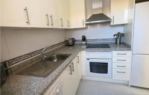 a white kitchen with a sink and a stove at Stunning Apartment In Duquesa With 2 Bedrooms, Outdoor Swimming Pool And Swimming Pool in Castillo de Sabinillas