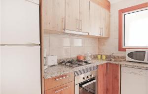 a kitchen with wooden cabinets and a stove top oven at Awesome Apartment In Malgrat De Mar in Malgrat de Mar