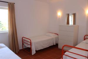 クアルテイラにあるApartment Casa Azulの小さな部屋で、ベッド2台、鏡が備わります。