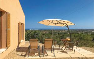 un patio con mesa, sillas y sombrilla en Awesome Home In Son Carri With Kitchenette, en Son Carrió
