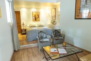 ein Schlafzimmer mit einem Bett und zwei Stühlen und einem Tisch in der Unterkunft La Ferme de l'Oudon & SPA in Berville