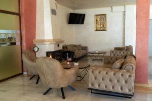 a living room with couches and a table and a fireplace at Hotel Paradise in Ognyanovo