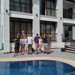 a group of people standing next to a swimming pool at MİYAS LUXURY HOTEL in Kemer