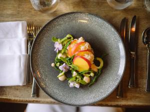 a gray plate with a salad on a table at Burgh Island Hotel in Bigbury on Sea
