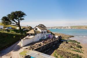 a group of people sitting outside a building on the beach at Burgh Island Hotel in Bigbury on Sea
