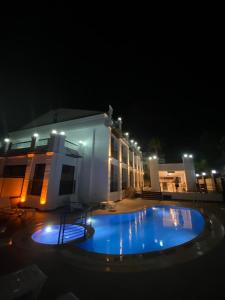 a house with a blue pool in front of a building at MİYAS LUXURY HOTEL in Kemer