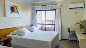 Un pat sau paturi într-o cameră la Golden Beach Hotel