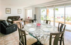 a dining room with a table and chairs and a couch at Nice Apartment In Santa Pola in Santa Pola