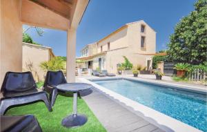 ナルボンヌにあるNice Home In Narbonne With 4 Bedrooms, Internet And Outdoor Swimming Poolの家の隣のプール(椅子、テーブル付)