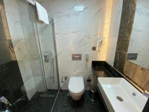 a bathroom with a toilet and a shower and a sink at MİYAS LUXURY HOTEL in Kemer