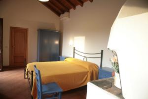 a bedroom with a bed and two blue chairs at Galea Farm House in Riposto