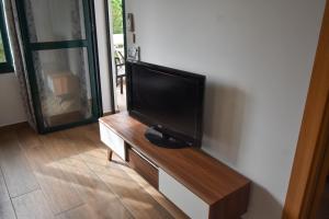 TV de pantalla plana en la parte superior de un centro de entretenimiento de madera en Urb Pueblo del Parque, Luxury 2 bedroom apartment. Fantastic central location., en Benalmádena