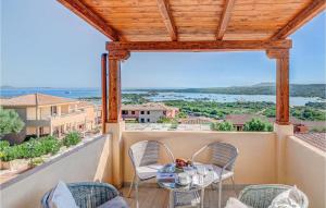 een patio met een tafel en stoelen op een balkon bij Gorgeous Apartment In Golfo Aranci With Kitchenette in Golfo Aranci