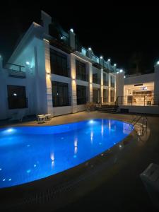 a large swimming pool in front of a building at night at MİYAS LUXURY HOTEL in Kemer