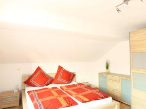 um quarto com uma cama com almofadas vermelhas e laranja em Weingut Michael Grünewald & Söhne em Bingen am Rhein