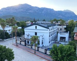 an aerial view of a white building with mountains in the background at MİYAS LUXURY HOTEL in Kemer