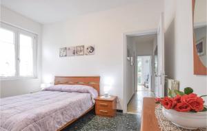1 dormitorio con 1 cama y un jarrón con rosas rojas en Pet Friendly Apartment, en Bracco