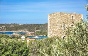 a large stone building with a body of water at Bilo 4 in Porto Cervo
