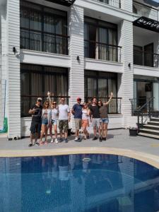 a group of people standing next to a swimming pool at MİYAS LUXURY HOTEL in Kemer