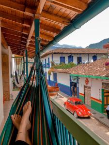 a person laying in a hammock looking at a car at Hostal Naty Luna in Jardin
