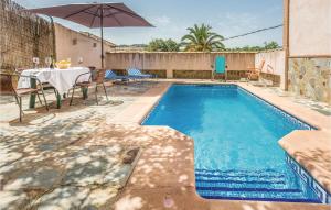 einen Pool mit einem Tisch und einem Sonnenschirm in der Unterkunft Amazing Home In Montecorto, Málaga in Montecorto