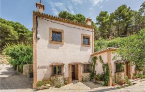 ein altes weißes Haus mit Fenstern und Reben in der Unterkunft Amazing Home In Montecorto, Málaga in Montecorto