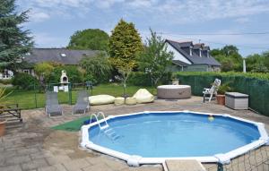 duży basen w ogrodzie z krzesłami i płotem w obiekcie Amazing Home In Callac De Bretagne With Kitchen w mieście Callac