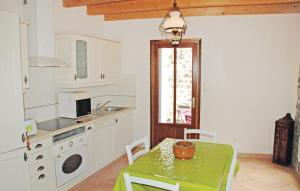 een keuken met een tafel met een groene tafel bij Lovely Home In St, Fortunat S Eyrieux With Kitchen in Saint-Fortunat-sur-Eyrieux