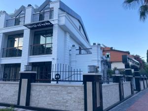 a white building with a fence in front of it at MİYAS LUXURY HOTEL in Kemer