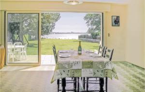 a dining room with a table with a bottle of wine at Nice Home In Locoal-mendon With 4 Bedrooms in Kerdavid