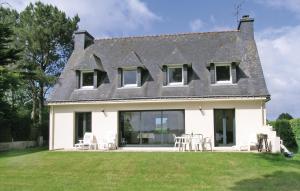 a white house with tables and chairs on the lawn at Nice Home In Locoal-mendon With 4 Bedrooms in Kerdavid